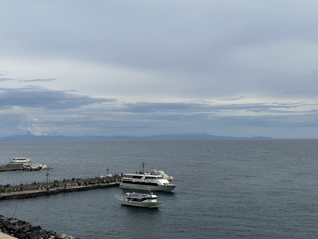 Boats at a pier of the Amalfi Harbour, viewed from the rental car on the Amalfi Drive