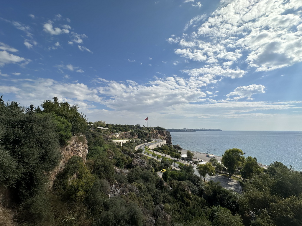 The Konyaalti Plaji road, flags, the city center and the Gulf of Antalya, viewed from the path at the top of the elevator from the Atatürk Kültür Park to the Beach Park