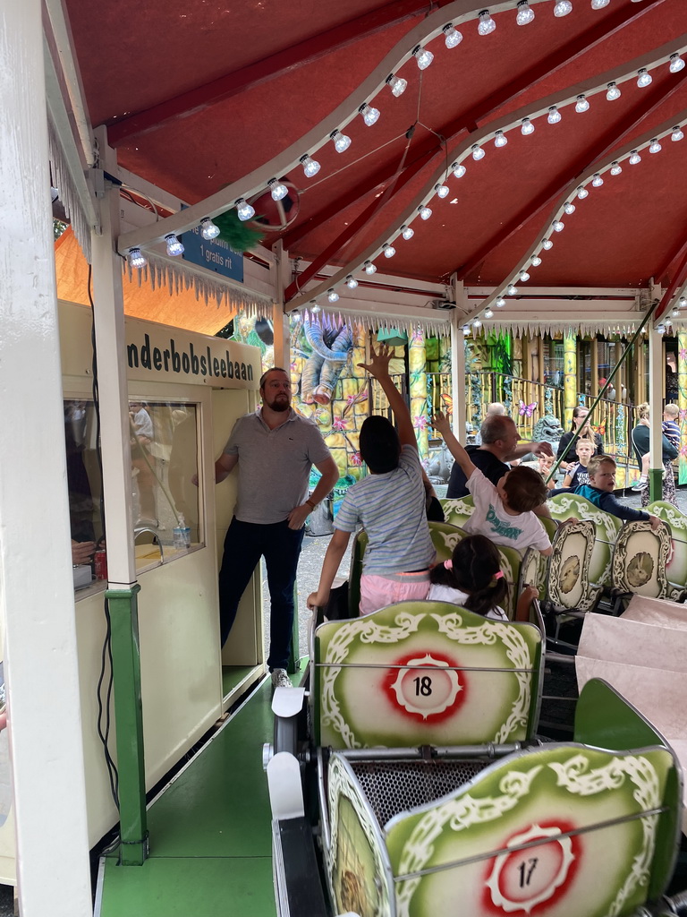 Max and his friend grabbing a plume at a carousel at the funfair at the Brigidastraat street