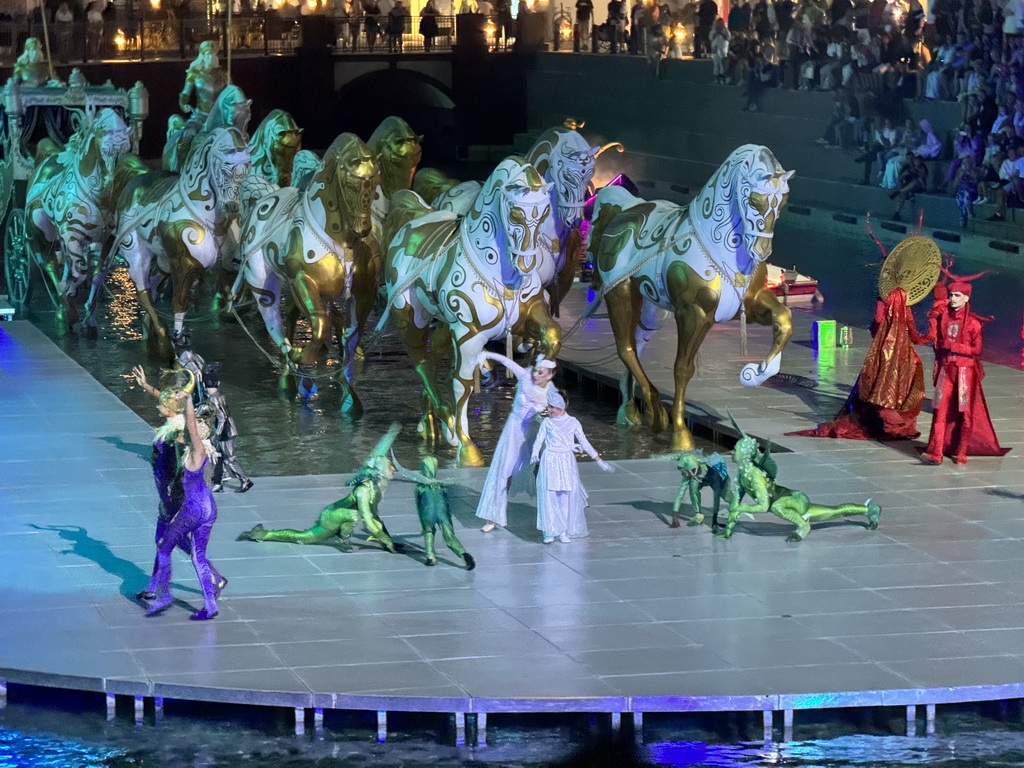 Actors and horse statues in front of the Chateau at the Shopping Avenue area of the Land of Legends theme park, during the Musical Boat Parade, by night