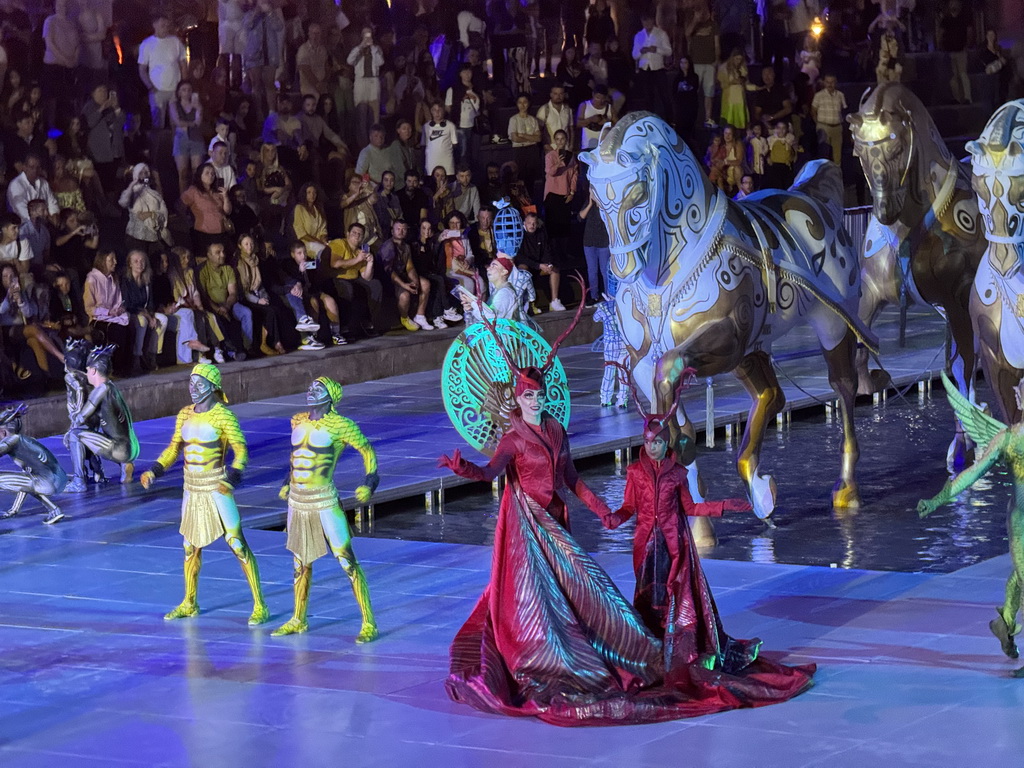 Actors and horse statues in front of the Chateau at the Shopping Avenue area of the Land of Legends theme park, during the Musical Boat Parade, by night