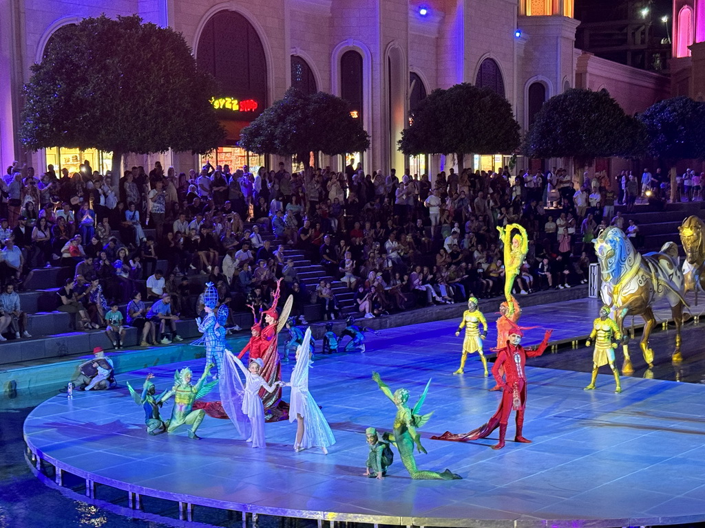 Actors and horse statues in front of the Chateau at the Shopping Avenue area of the Land of Legends theme park, during the Musical Boat Parade, by night