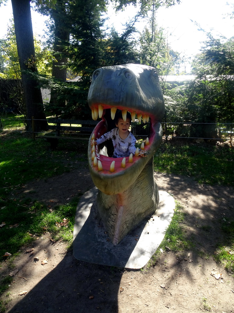 Max in a statue of the head of a Dinosaur at the playground in the Oertijdwoud forest of the Oertijdmuseum