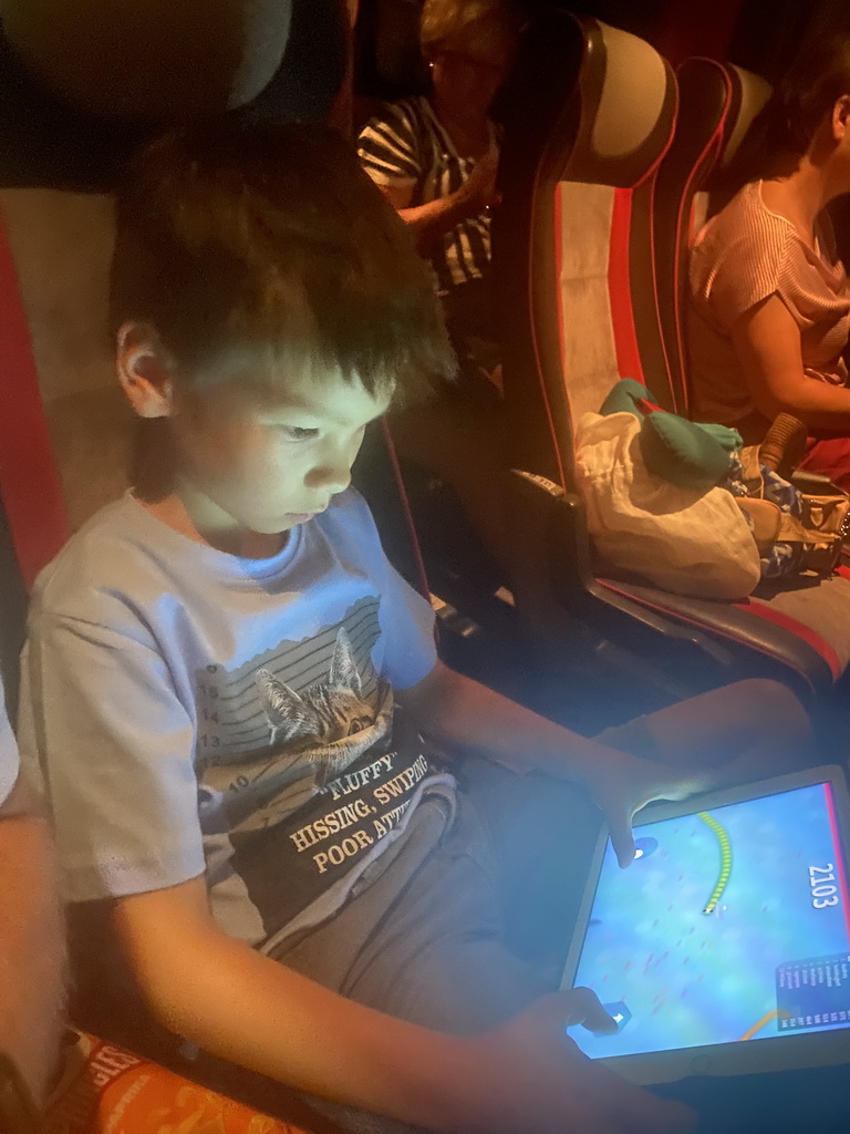 Max playing on the iPad in the tour bus from Perast on the D8 road near the town of Zvekovica