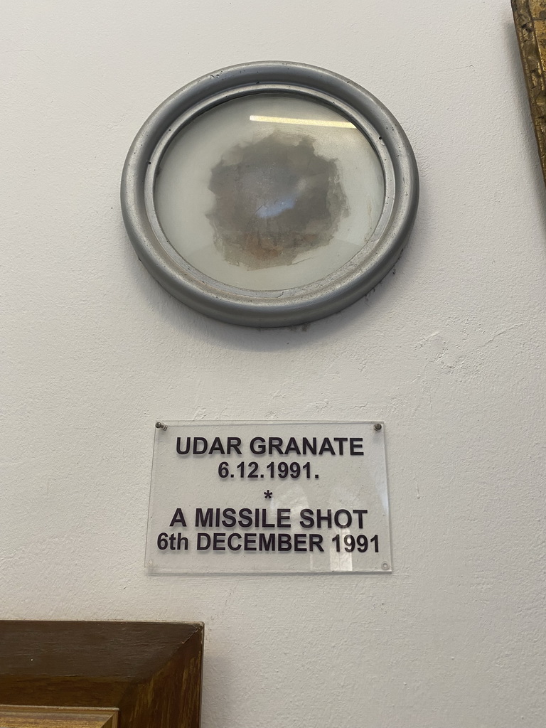 Hole from a missile shot at the museum at the Franciscan Monastery, with explanation