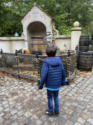 Max in front of wooden barrels, fox tail and bird at the Pinocchio attraction at the Fairytale Forest at the Marerijk kingdom