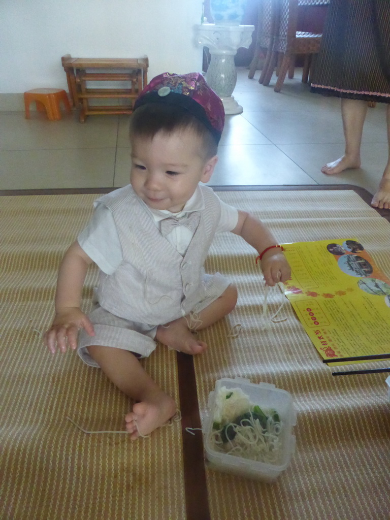 Max eating noodles for his first birthday in the apartment of Miaomiao`s parents