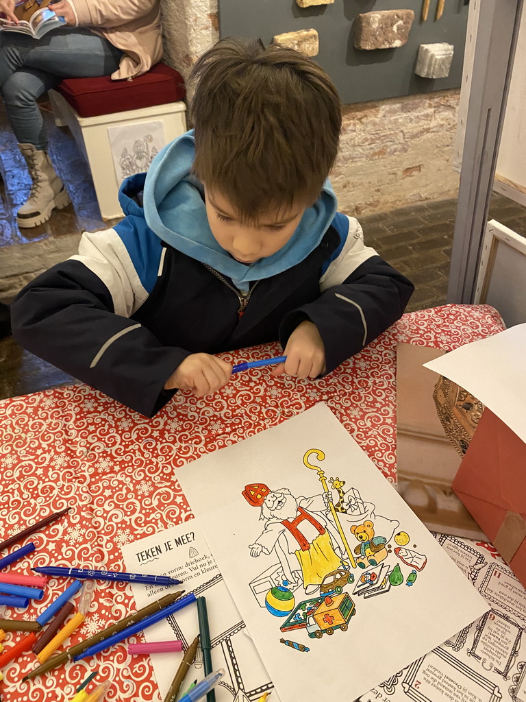 Max with a colouring page at the museum room at the basement of the main building of the Heeswijk Castle, during the `Sint op het Kasteel 2022` event