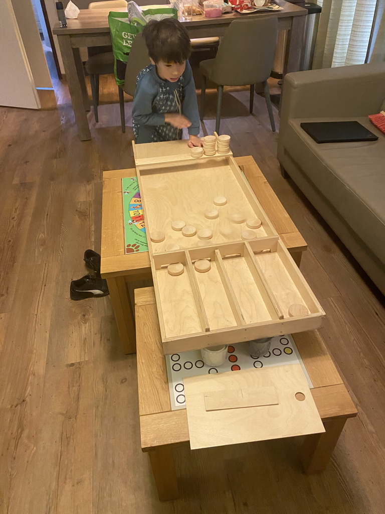 Max playing shuffleboard in the living room of our holiday home at the Landal Miggelenberg holiday park