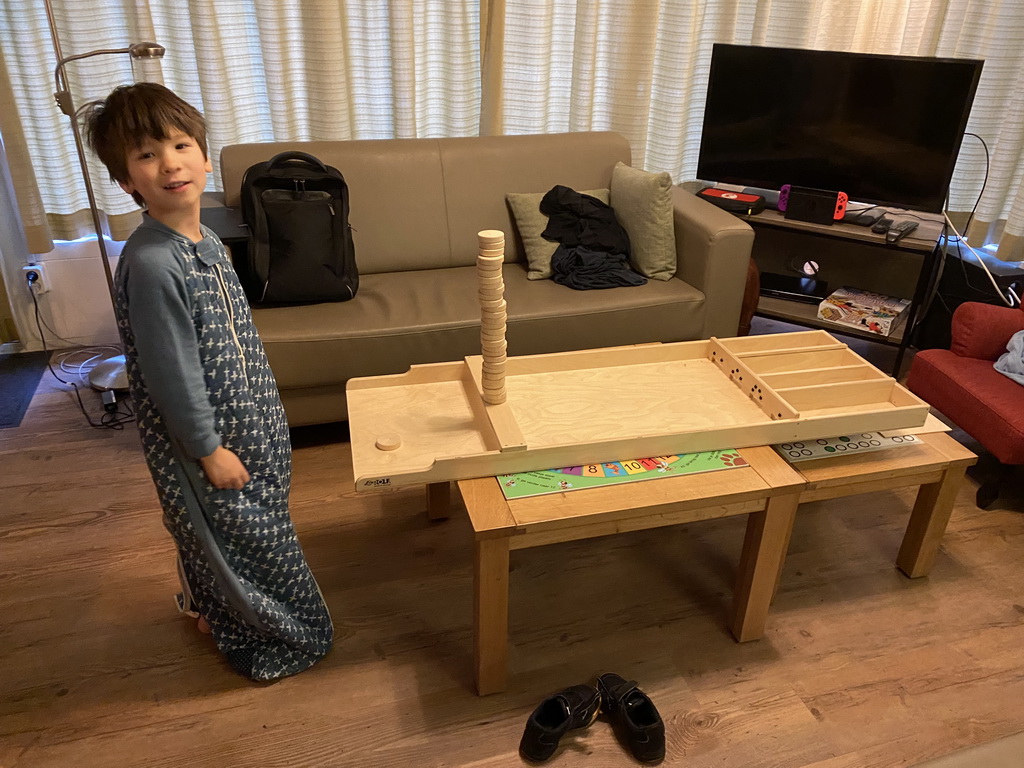 Max playing shuffleboard in the living room of our holiday home at the Landal Miggelenberg holiday park