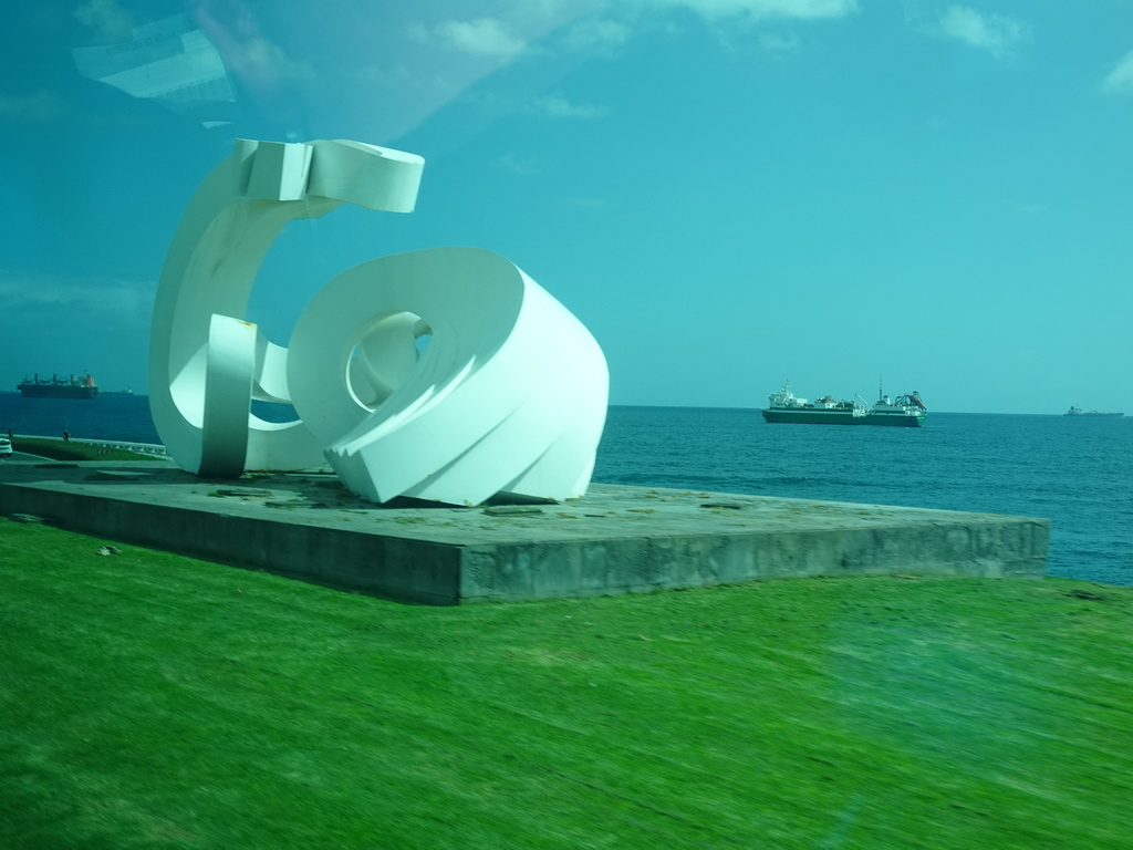 Ships in the Atlantic Ocean and the sculpture `Arimaguada`, viewed from the bus from Maspalomas on the GC-1 road