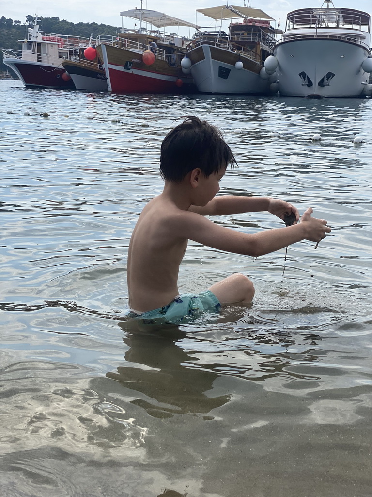 Max playing with sand the Plaa Dubrava Pracat beach and boats at the Lopud Harbour