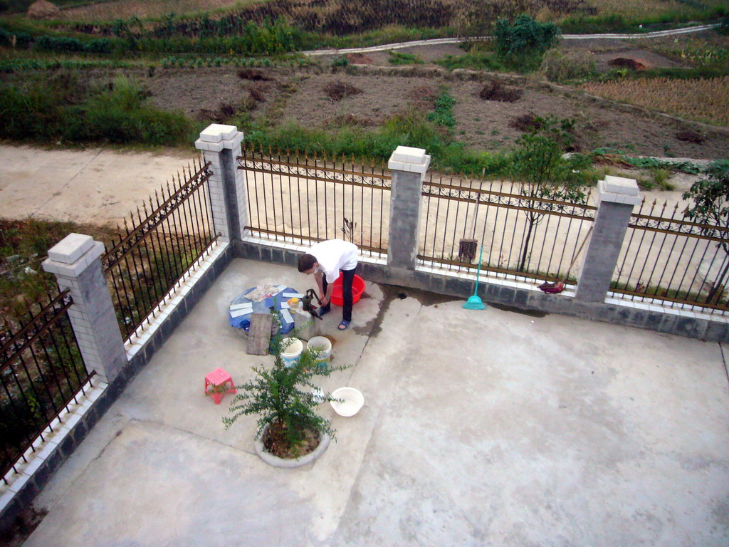 Tim getting water in front of Miaomiao`s grandparents` house, viewed from the roof