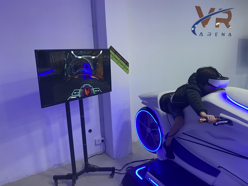 Max doing a virtual reality motor cycle game at the VR Arena at the Yumbo Centrum shopping mall