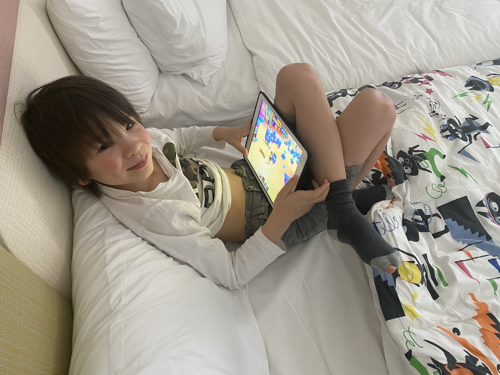 Max playing with iPad on the bed in our room at the Abora Buenaventura by Lopesan hotel