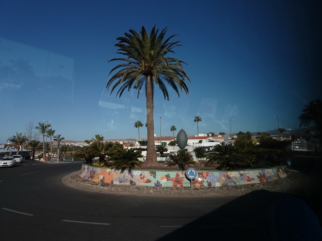 Palm tree and piece of art at the Plaza Hierro square, viewed from the tour bus to Puerto Rico