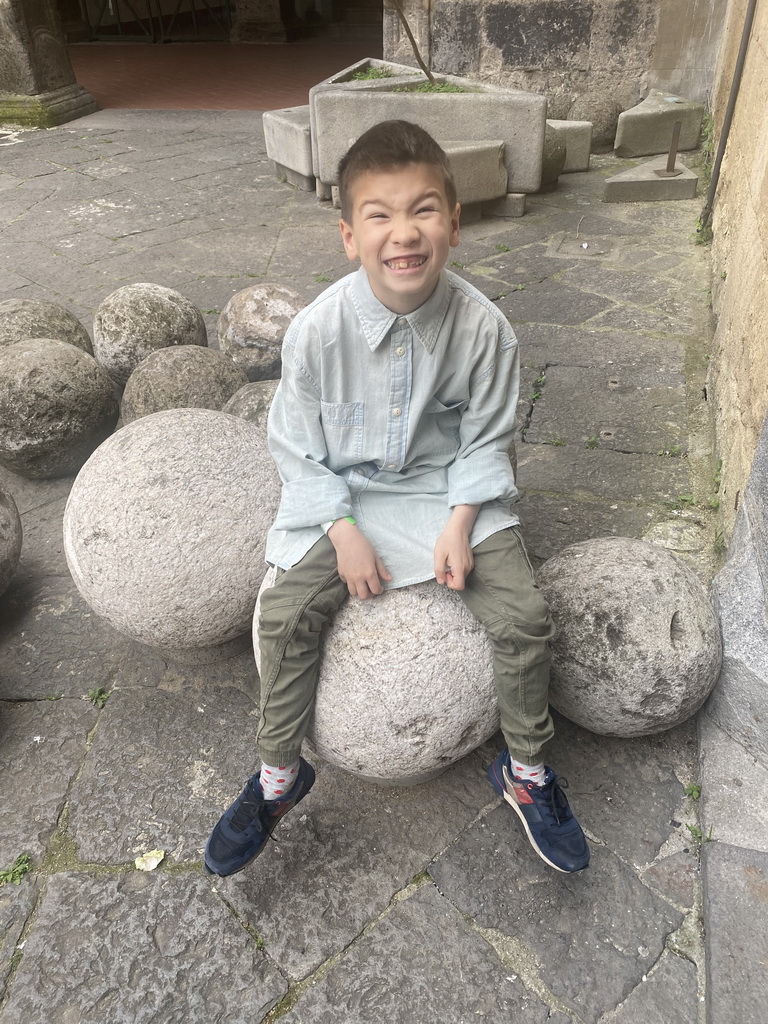 Max sitting on stone cannon balls at the inner square of the Castel Nuovo castle