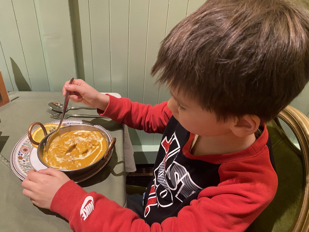 Max eating curry at the India Gate restaurant