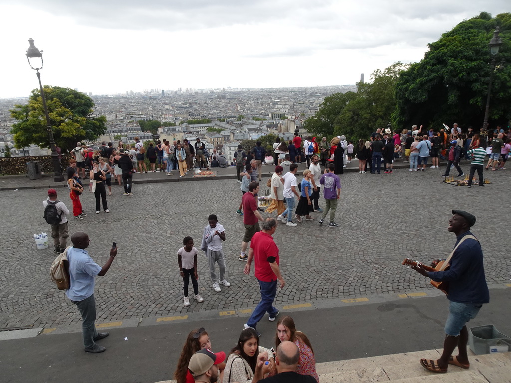 Musician at the Parvis du Sacré-Coeur square and the city center, viewed from the front of the Basilique du Sacré-Coeur church