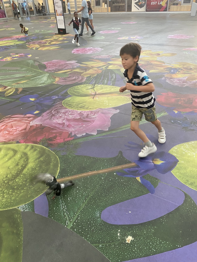 Max chasing pigeons on a painted floor at the Westfield Forum des Halles shopping mall