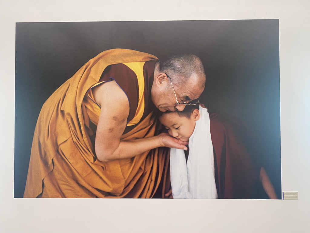 Photograph of the Dalai Lama and a child at the exhibition `Hymne à la Beauté` at the top floor of the Grande Arche de la Défense building