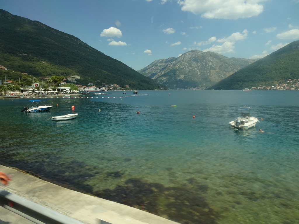 Boats at the Bay of Kotor, beach at the town of Kamenari and the town of Perast, viewed from the tour bus on the E65 road