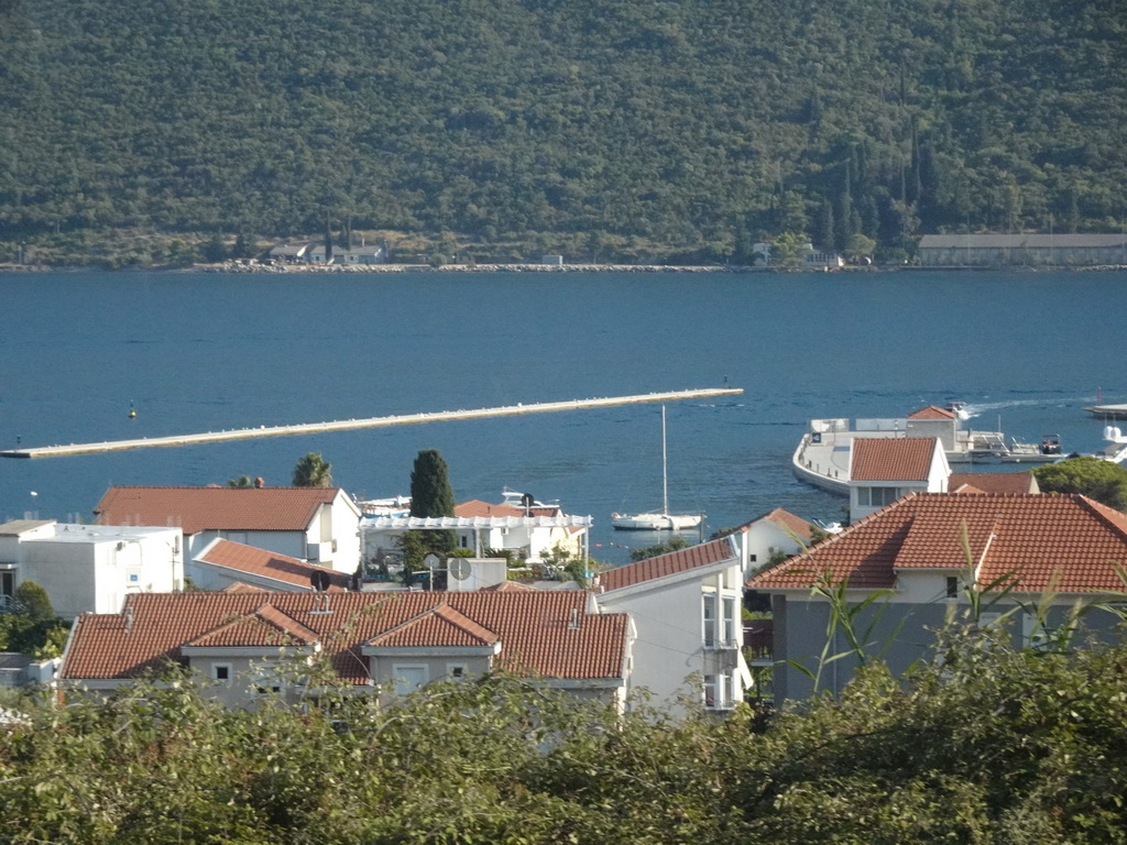 The Bay of Kotor and houses and a pier at the Portonovi Marina at the town of Kumbor, viewed from the tour bus on the E65 road