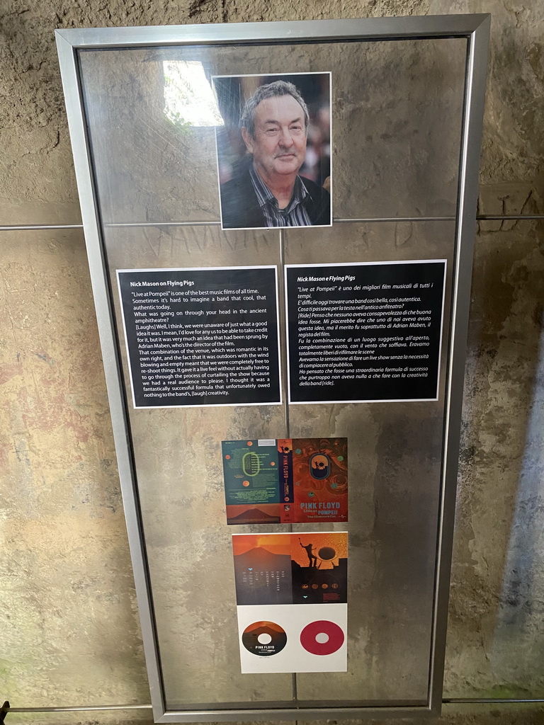 Photograph of Nick Mason and cover art of the `Pink Floyd - Live at Pompeii` movie at the southwest catacombs of the Amphitheatre at the Pompeii Archeological Site