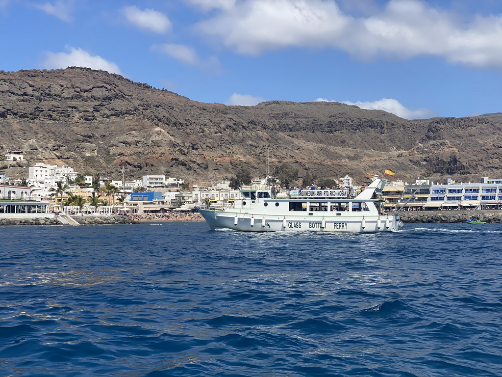 Boat in front of the Playa Puerto De Mogan beach, viewed from the Sagitarius Cat boat