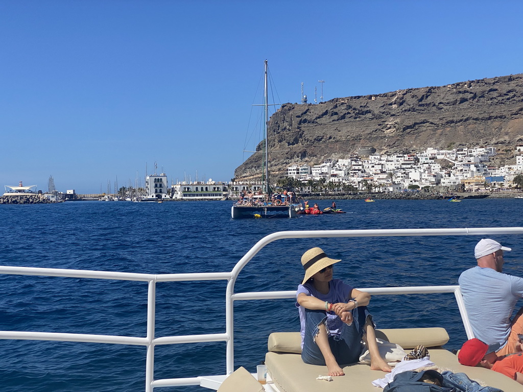 Boat and jet skis in front of the town center with the pavilion of Beach Club Faro, the harbour and the Hotel THe Puerto de Mogán, viewed from the Sagitarius Cat boat