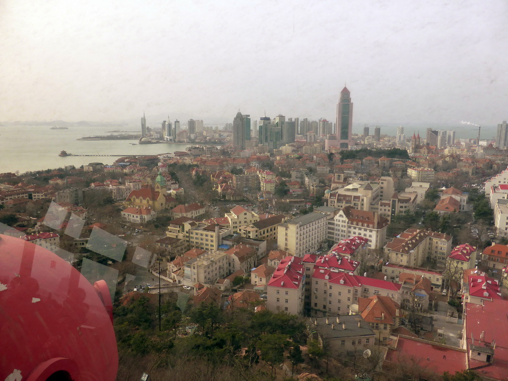 The city center with skyscrapers, St. Michael`s Cathedral and the Qingdao Protestant Church, Qingdao Bay with the Zhan Qiao Pier and the skyscrapers and dome at the west side of the city, viewed from the rotating sightseeing tower at the Xinhaoshan Park