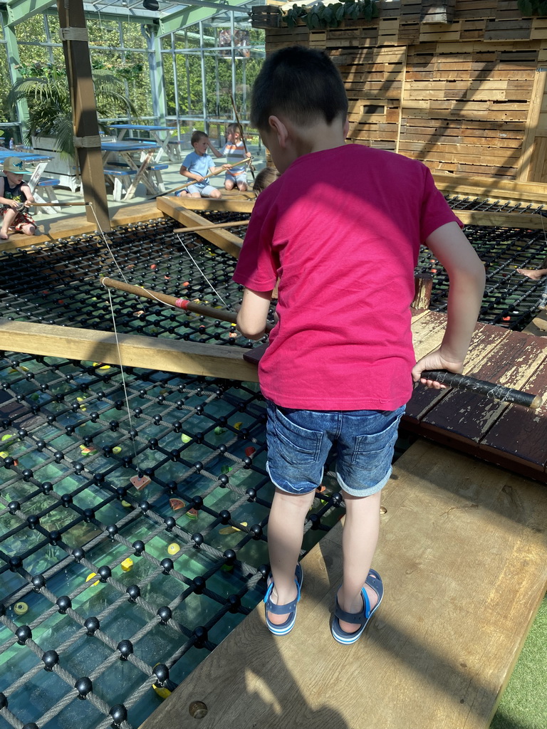 Max doing a fishing game at the Huis in de Heuvel building at the Speelwijck area of the Plaswijckpark recreation park