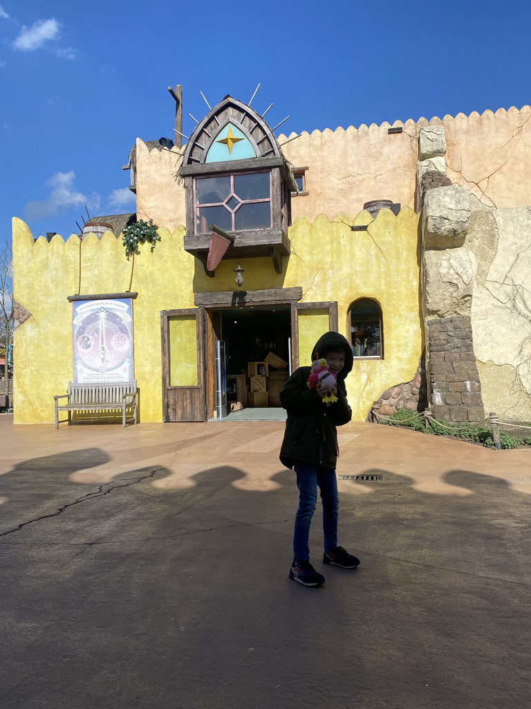 Max with the plush mascot Ivy in front of the Exploria Magica attraction and Mundo Magica shop at the Port Laguna section at the Toverland theme park