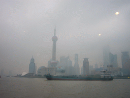 Boat in Huangpu river and the skyline of the Pudong district, with the Oriental Pearl Tower, viewed from the Huangpu river ferry