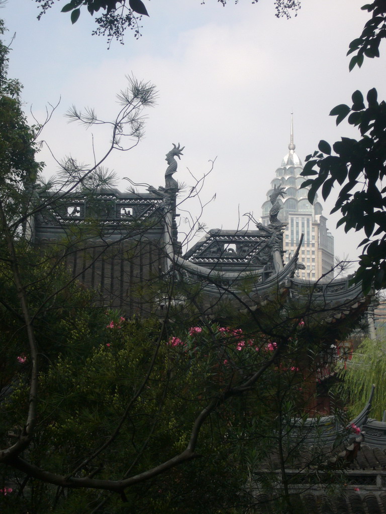 Roofs and trees in the Yuyuan Garden in the Old Town, with a view on the Guang Ming Building