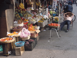 Man sleeping outside of fruit shop in a Lilong