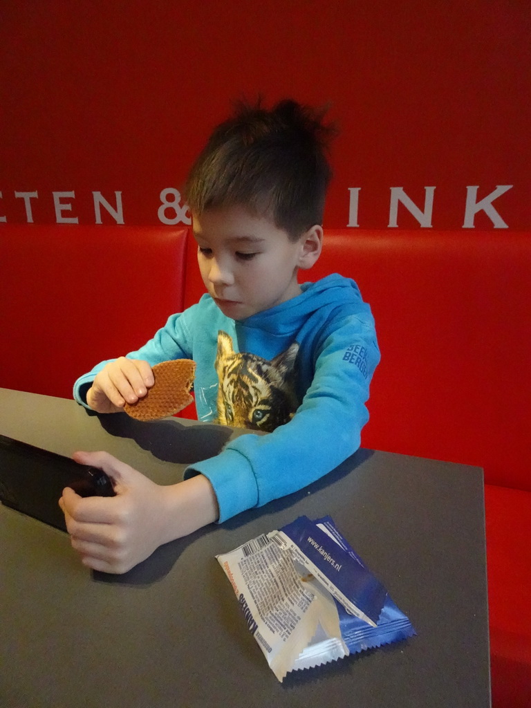 Max with iPhone and a stroopwafel at the Museumcafé at the ground floor of the Natuurmuseum Brabant