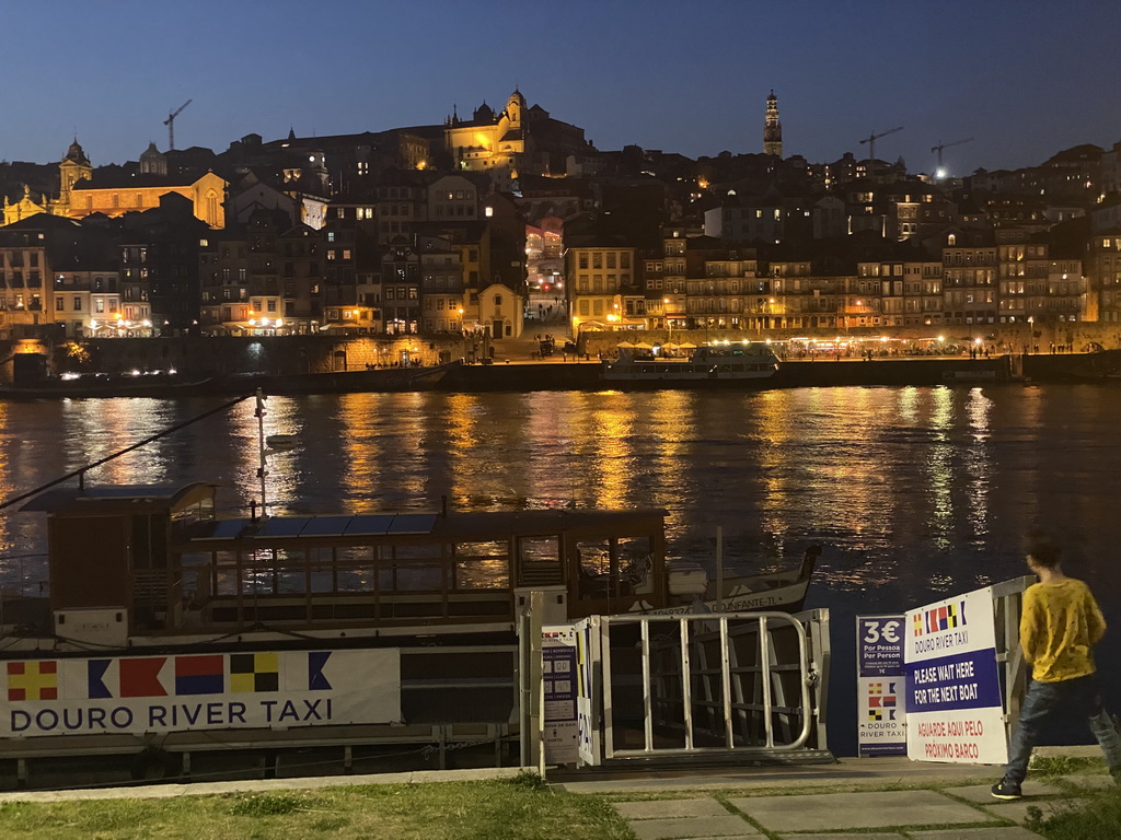 Max in front of the ferry over the Douro river at the ferry dock at the Avenida de Diogo Leite street and Porto with the Igreja Monumento de São Francisco church, the Igreja de Nossa Senhora da Vitória church and the Torre dos Clérigos tower, by night