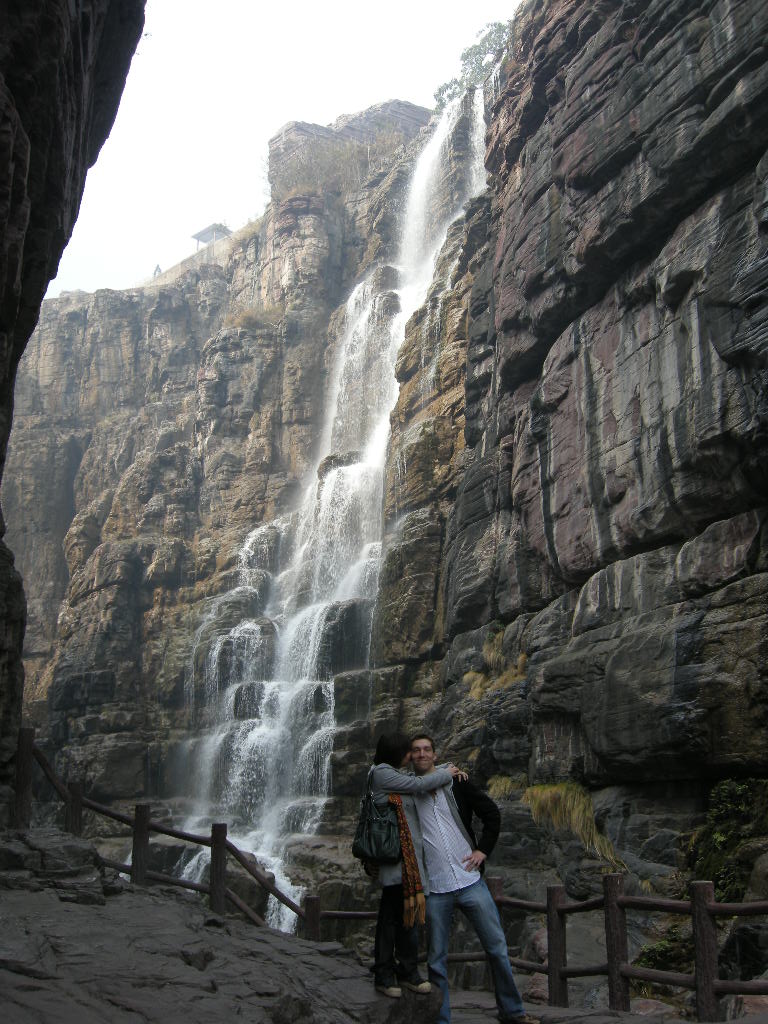 Tim and Miaomiao at the mountainside path at the Red Stone Gorge at the Mount Yuntaishan Global Geopark, with a view on the waterfall